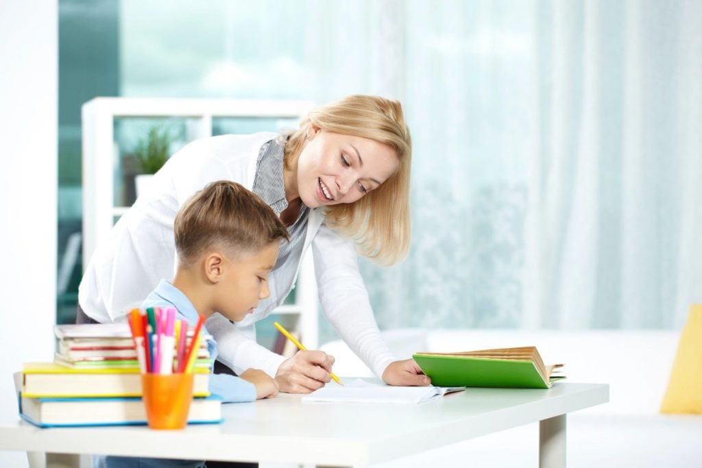 A woman helping a boy with homework