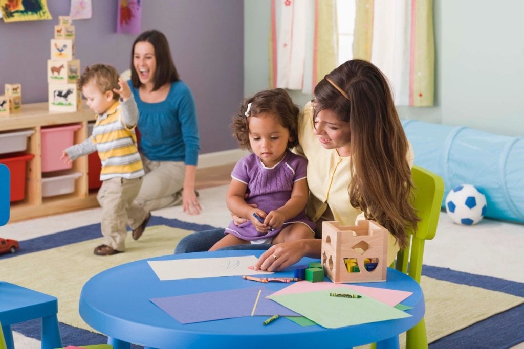 A woman sitting at a table with two children.